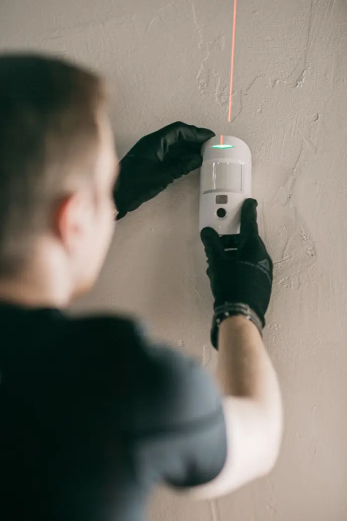 Técnic de polser instal·lant un sensor de moviment.